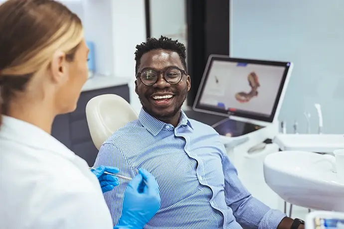 A dental crown sitting on a person's finger