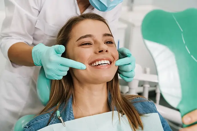 A dental crown sitting on a person's finger
