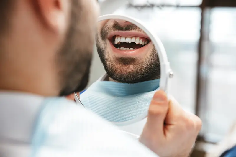 A dental crown sitting on a person's finger